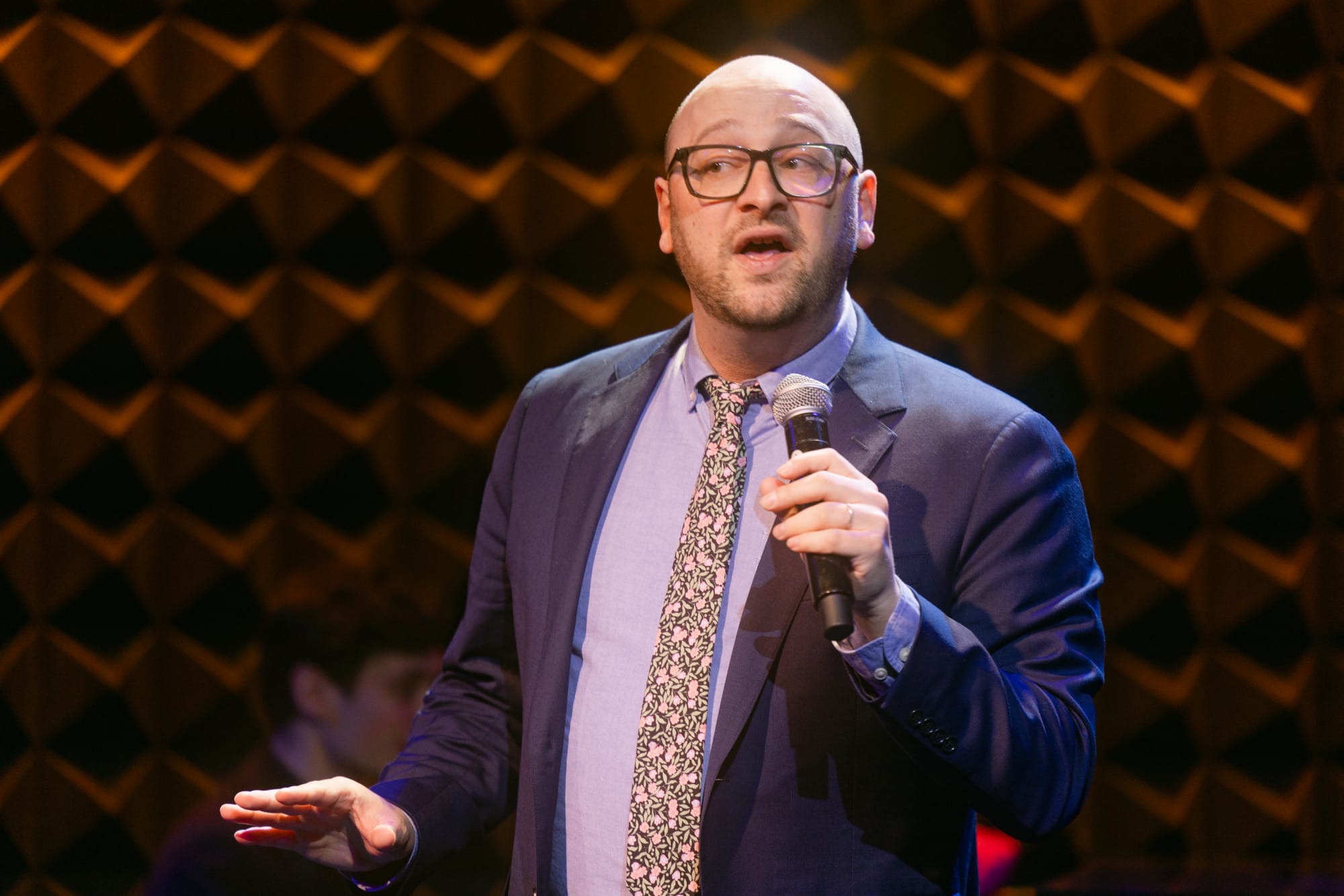Me wearing a suit and tie onstage at Joe's Pub. I'm making a skeptical or unsure expression.