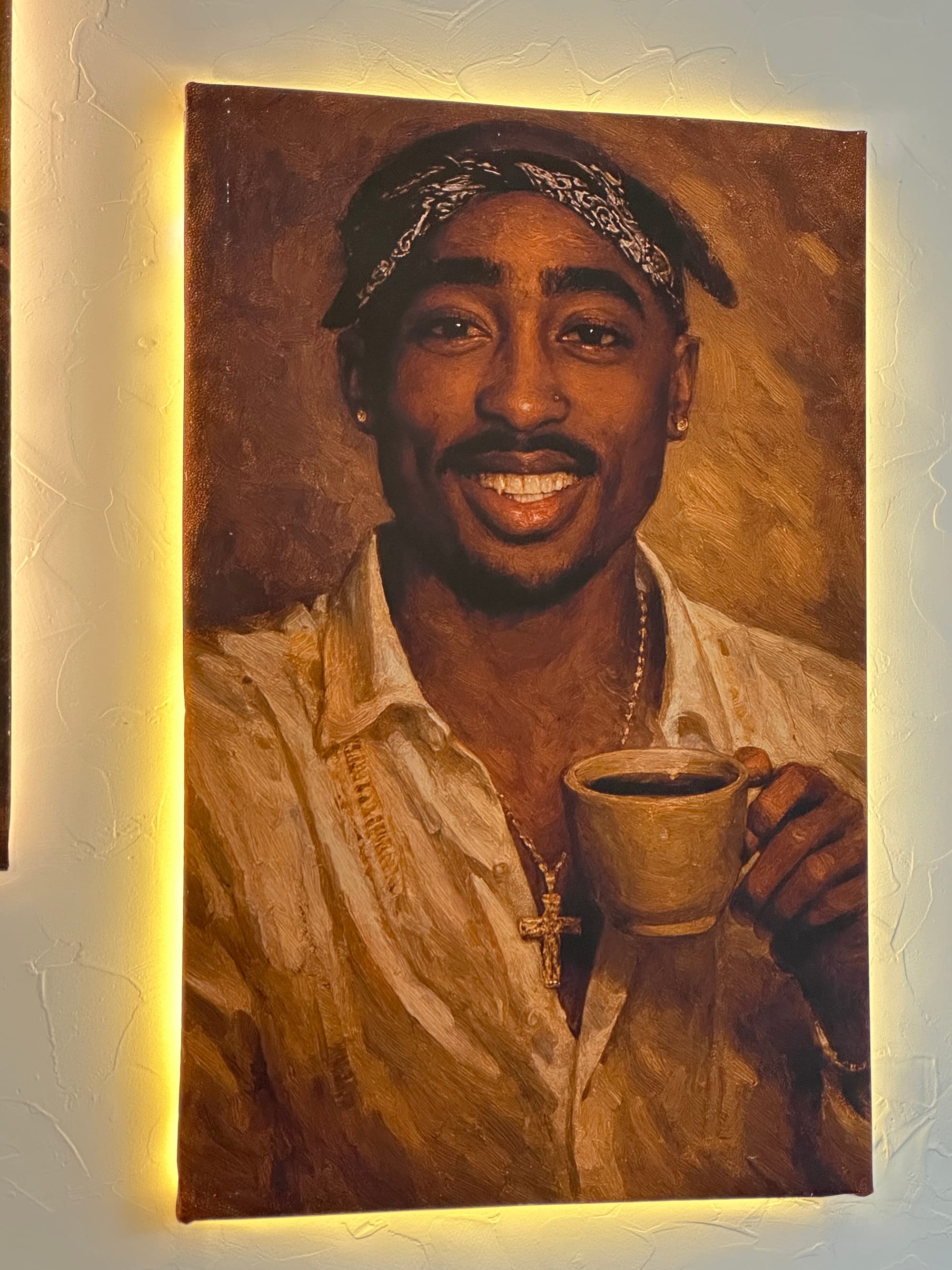 A painting (?) of 2Pac happily holding a mug of coffee.