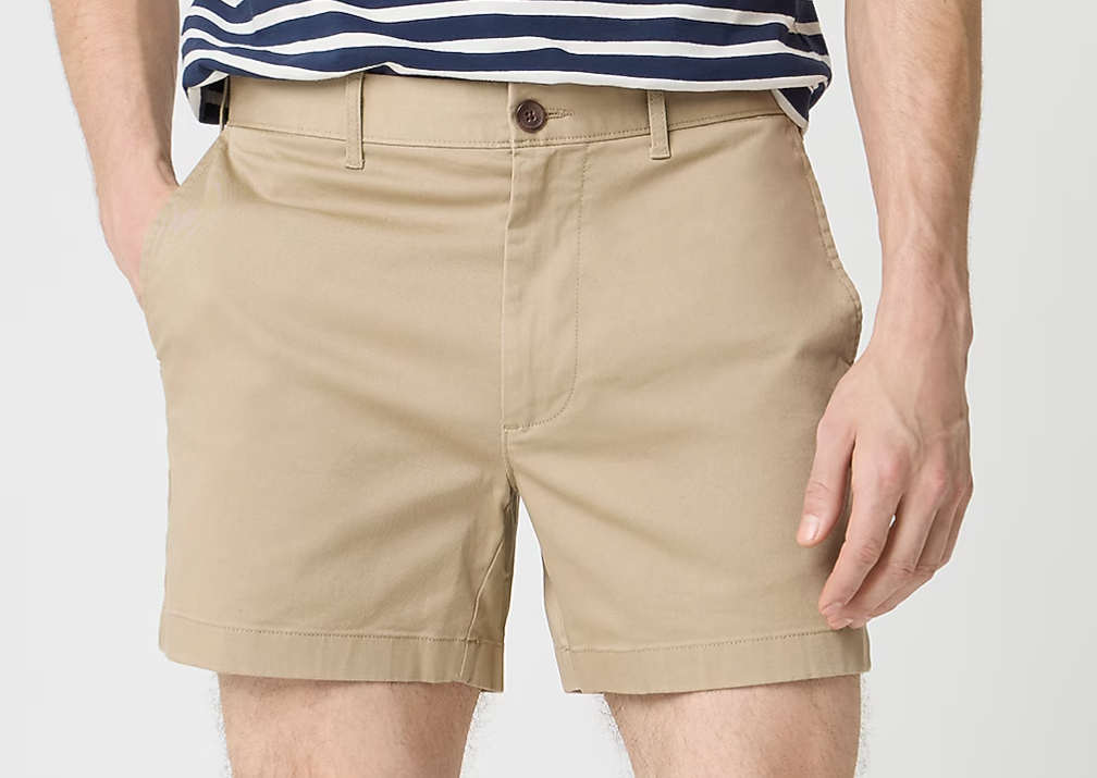 Khaki shorts on a guy with slightly hairy legs who is wearing a blue and white striped shirt and no belt.